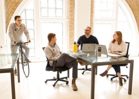 Kaleidoscope employees talking at a desk