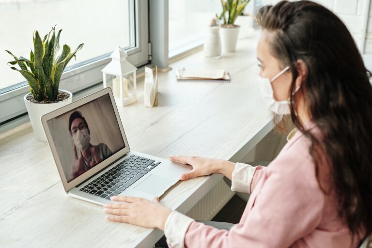 Woman talking to man on laptop