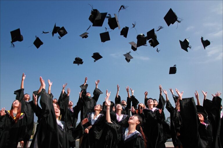 Students in graduation robes throwing their caps