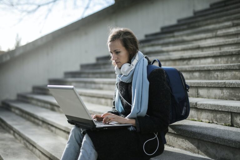 Woman working on laptop on stairs