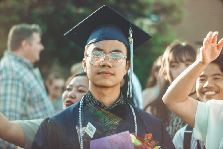 Man smiling with graduation robes on