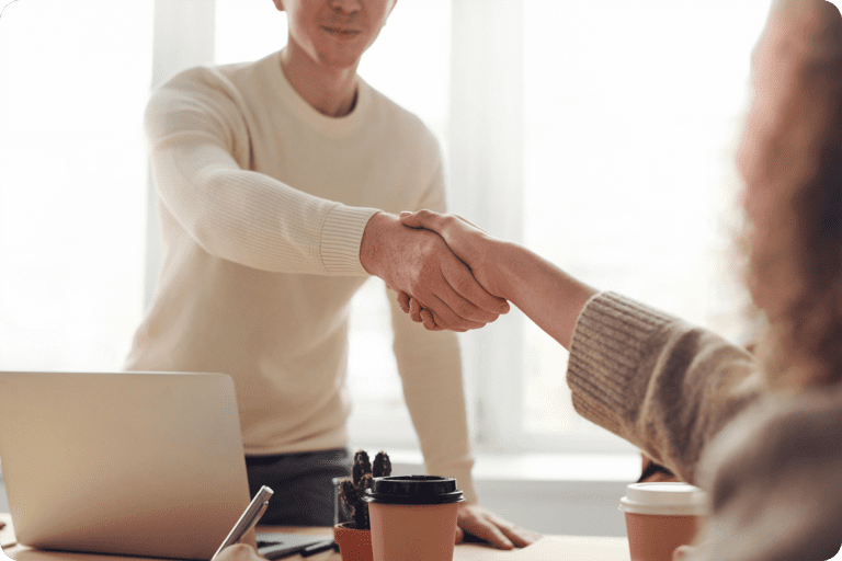 Two people shaking hands in an office setting